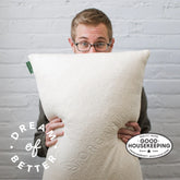 Man holding Avocado Green Pillow image shows Good Housekeeping Seal