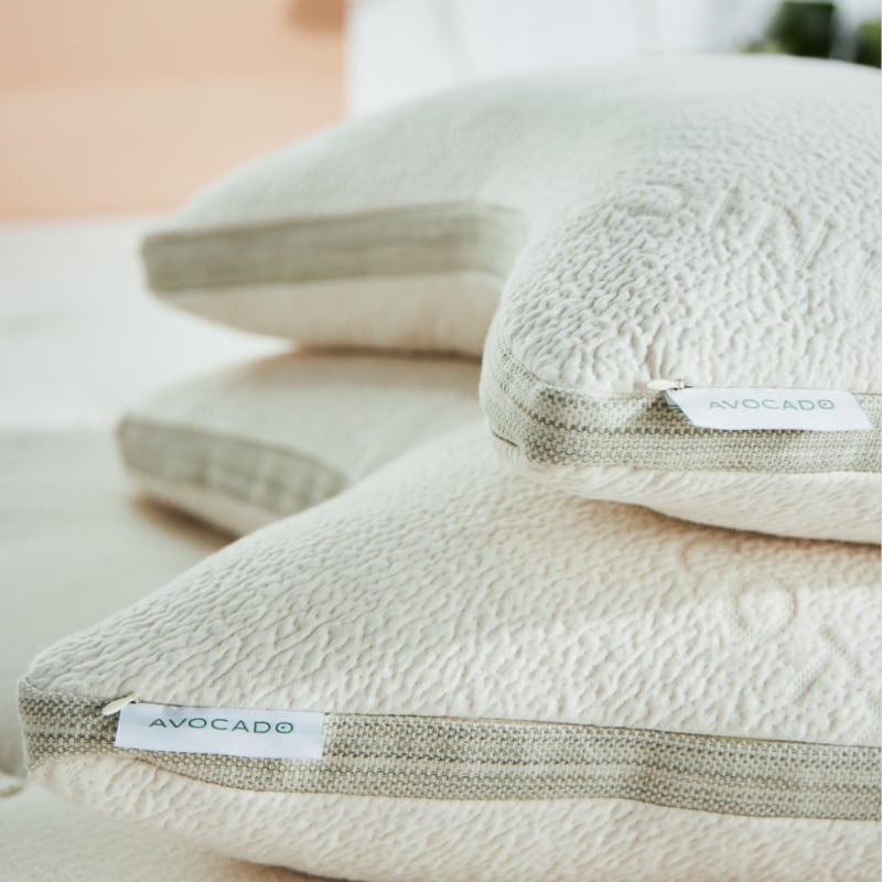 Two Avocado Side-Sleeper Pillows stacked on a bed