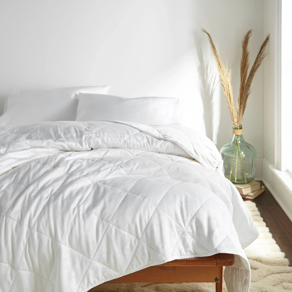 Eye-level shot from the right side of the bed featuring  bamboo comforter smoothly laid out, highlighting its soft drape and elegant texture.